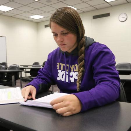 Student reading a book in class